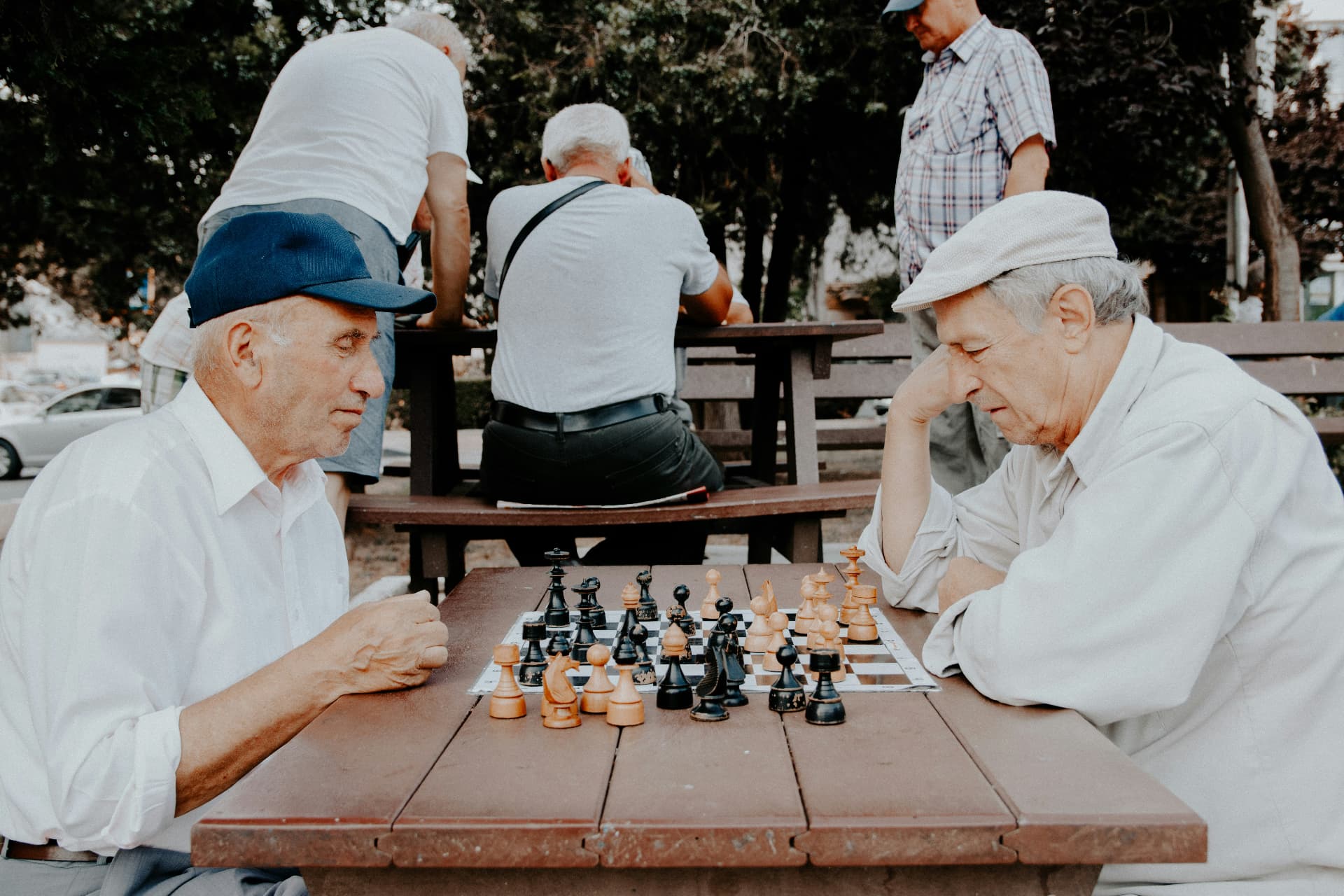 Zwei ältere Männer spielen gemeinsam Schach im Park