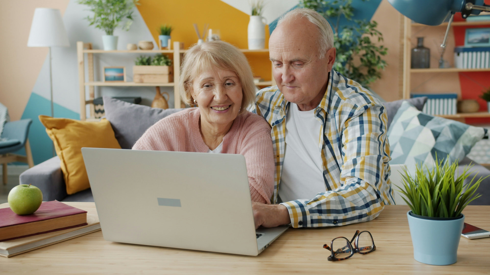 Ein älteres Paar entdeckt gemeinsam Angebote am Laptop